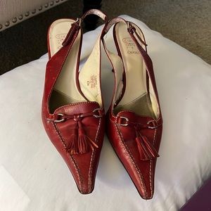 Sling back pump with silver accessories and tassel.